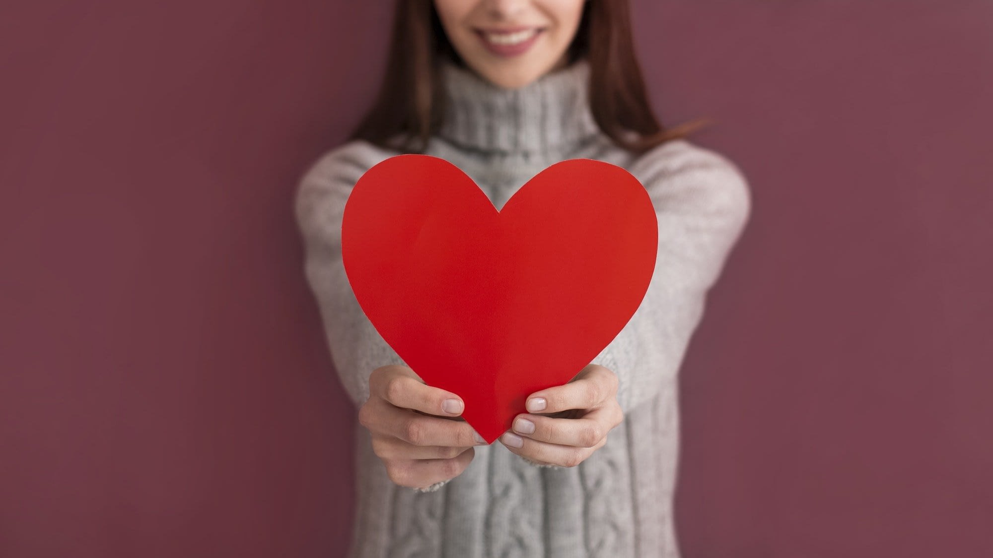 Cropped view of caucasian girl holding heart shaped card